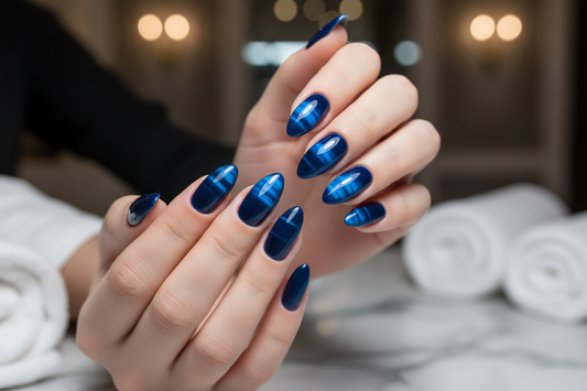 Close-up of hands with sapphire blue cat eye gel nail polish showing magnetic shimmer effect and glossy finish